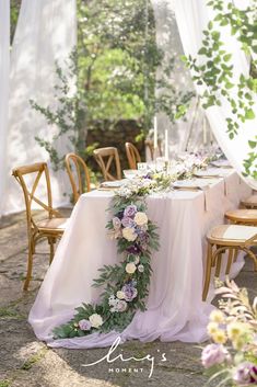 the table is set with flowers and greenery for an outdoor wedding reception in france