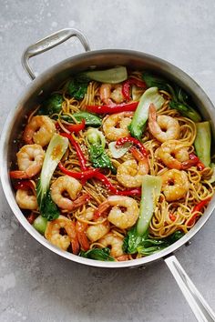 a pan filled with shrimp, noodles and veggies