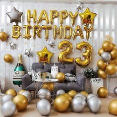 a room filled with balloons and furniture next to a number 23 sign that says happy birthday