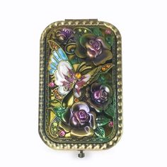 a small metal box with flowers and butterflies on it