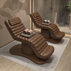 two brown leather chairs sitting on top of a rug