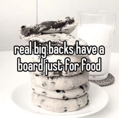 a stack of cookies sitting on top of a white plate next to a glass of milk