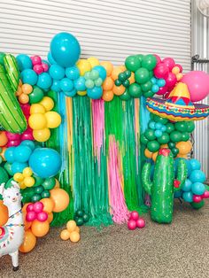 an assortment of balloons and streamers on display in front of a wall with a horse