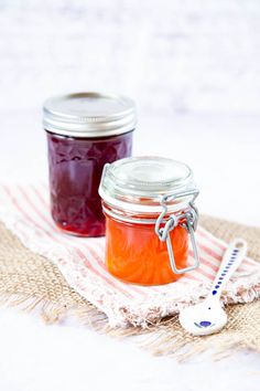 two jars filled with jam sitting on top of a table