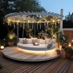 a white couch sitting on top of a wooden deck next to potted plants and lights