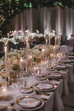 a long table is set with white flowers and candles for an elegant wedding reception at the park hyatton