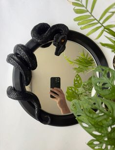 a person taking a selfie in front of a mirror with a snake on it