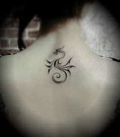 the back of a woman's neck with a tattoo design on her left side