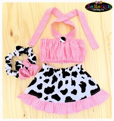 a cow print outfit and headband on a wooden surface