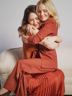 two women hugging each other on a couch