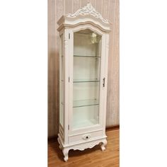 a white china cabinet sitting on top of a hard wood floor next to a wall