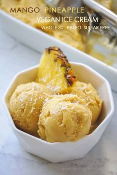 mango pineapple vegan ice cream in a white bowl on a marble counter top