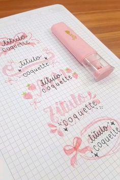 a pink pen sitting on top of a notebook with writing in french and english words