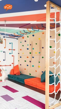 an indoor climbing wall with colorful ropes and pillows