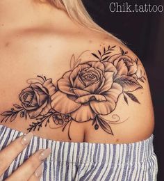 a woman's shoulder with flowers and leaves tattoo on her left side breast piece