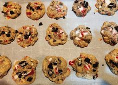 chocolate chip cookies with white and red toppings on a baking sheet lined with parchment paper