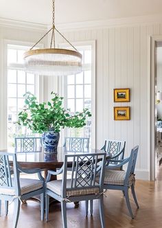 a dining room table with blue chairs and a potted plant on the top of it