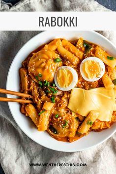 a white bowl filled with noodles and eggs next to chopsticks on a table