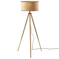 a wooden tripod floor lamp with a beige shade on it's side and a white background