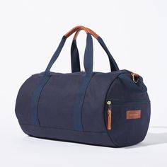 Sporty pals, we’ve had our not-so-sporty-bags stolen just one too many times, so we made you your own. Fabricated of our durable yet lightweight 12 oz canvas and accented with tonal navy webbing this is the perfect grab and go bag. A pair of sneakers, change of clothes, and shower essentials and we’ll have you from the gym to the office in no time. Carry the duffle with the handles or sling it over your shoulder with the removable strap. Functional Canvas Duffle Bag With Luggage Sleeve, Canvas Travel Bag For Everyday Use, Sporty Canvas Gym Bag For Travel, Casual Duffle Bag With Leather Handles For Outdoor, Casual Travel Bag With Leather Trim And Coated Canvas, Casual Navy Bag For Outdoor, Casual Navy Bags For Outdoor, Casual Travel Bag With Leather Trim For Overnight Trips, Casual Navy Outdoor Bag