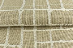 a close up view of the fabric on a bed sheet that is made out of beige and white squares