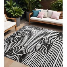 a black and white area rug on top of a wooden floor next to two couches