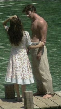 a man standing next to a woman on top of a pier