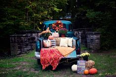 an old pickup truck with fall decorations on the bed and in the back, sitting outside