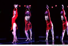 four women in red dresses are performing on stage