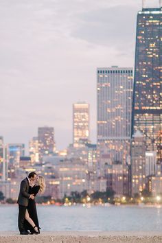 a couple kissing in front of the city skyline