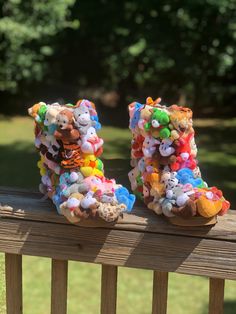 there is a pair of shoes made out of stuffed animals on a wooden bench in the park