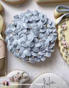 cookies decorated with blue flowers and white icing are on a table next to cookie cutters