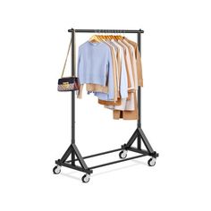 an ironing rack with clothes hanging on it and a handbag next to it