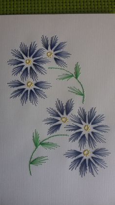 some blue flowers are on a white cloth