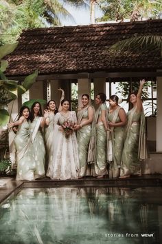 a group of women standing next to each other in front of a pool