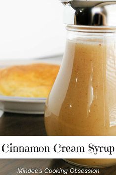 a glass jar filled with liquid sitting on top of a table next to a pastry