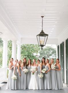 a group of bridesmaids posing for a photo on the porch