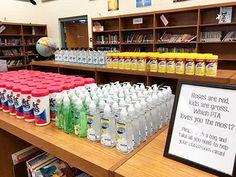 there are many bottles of water on the table in the library with a sign that says, please and not to drink