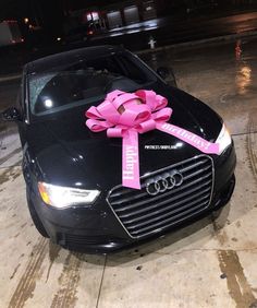 a black car with a pink bow on the hood