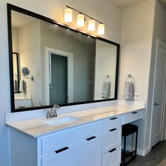 a bathroom with two sinks and a large mirror over it's counter top area