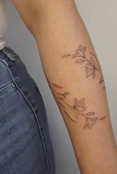 a woman with a tattoo on her arm holding onto the arm of another person's arm