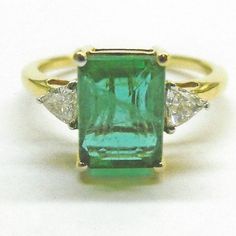 2.15ct Zambian Emerald W/0.24ct Diamonds. Rectangular (Octagon ? On Authentication) 8.75 X 6mm Emerald. L1 Clarity From Zambia. Plus 2 X Trillion (Triangle On Authentication) Diamonds. G/H Color, Si1/2 Clarity, 3 X 3mm From Africa. Set In 2.60gms Of 18k Gold. Comes With Certificate Of Authenticity And Replacement Appraisal Of $5,000. Also, For Your Peace Of Mind, Qualifies For Free Poshmark Authentication. Never Worn, From Owners Collection, Size 7. Please Ask As Many Questions As Make You Comfo Luxury Gia Certified Emerald Cut Gemstones, Gia Certified Diamond Gemstones, Gia Certified Diamond Jewelry With Trillion Cut, Gia Certified Trillion Cut Diamond Jewelry, Luxury Trillion Cut Emerald Ring For Formal Occasions, Classic Gia Certified Emerald Cut Gemstones, Elegant Gia Certified Trillion Cut Ring, Luxury Trillion Cut Diamond Emerald Ring, Luxury Trillion-cut Emerald Ring