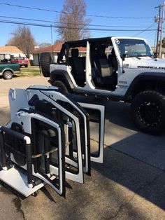 two jeeps are parked next to each other on the street with their doors open