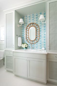 a bathroom with blue and white wallpaper on the walls, two sinks and a large mirror