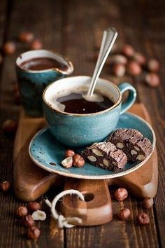 two cups of coffee and some cookies on a wooden table