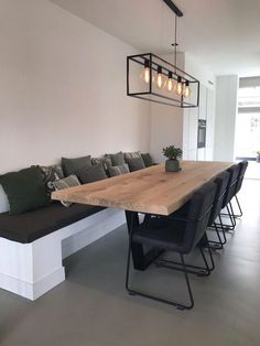 a wooden table sitting in the middle of a living room next to a long bench