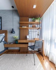 a bed room with a neatly made bed next to a wooden desk and shelves on the wall