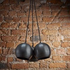 two black boxing gloves hanging from a brick wall