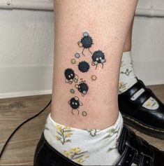 a small tattoo on the ankle of a woman's leg with three black sheep