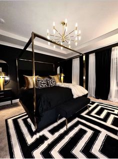 a black and white bedroom with a canopy bed, chandelier and rugs